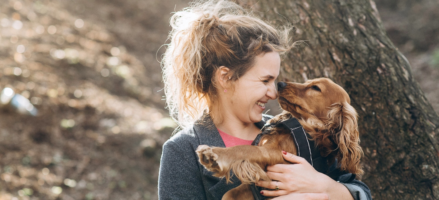 Woman hugs her dog after a veterinary soft tissue suregery in Tucson